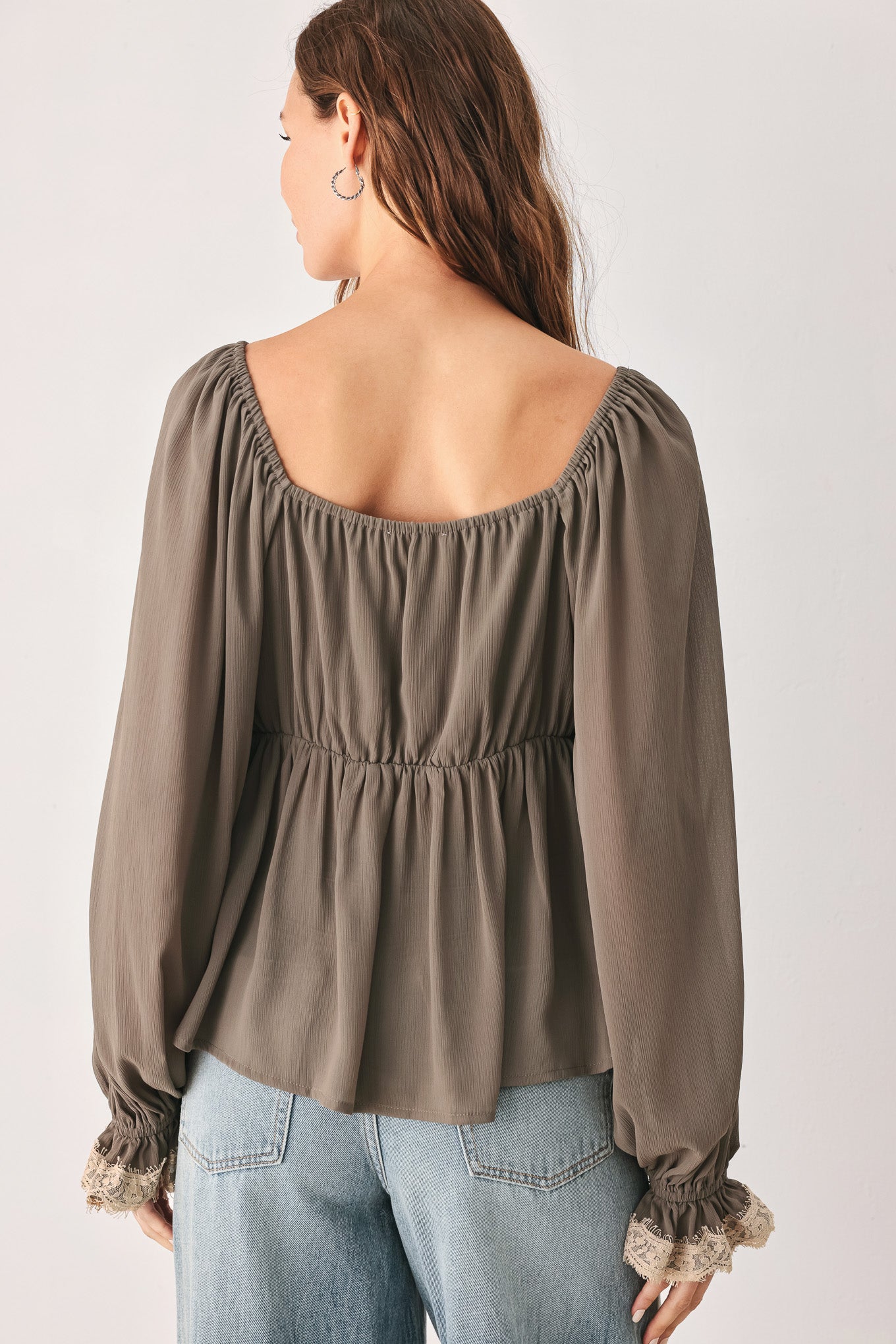 A woman wearing a taupe-brown long-sleeve blouse with beige lace trim on the neckline and cuffs | FREEMARKET