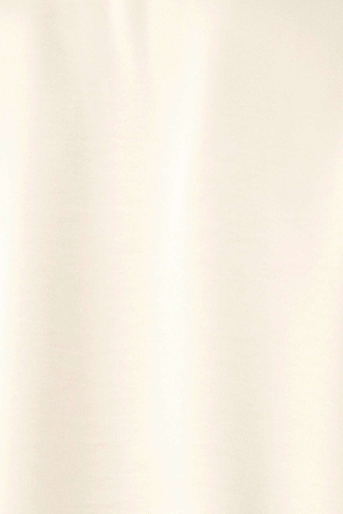 A woman wearing a cream-colored long-sleeve blouse with a tie-neck detail | FREEMARKET