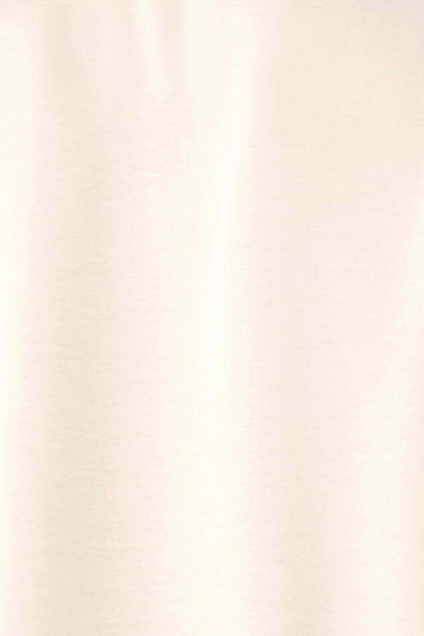 A woman wearing a cream-colored long-sleeve blouse with a tie-neck detail | FREEMARKET