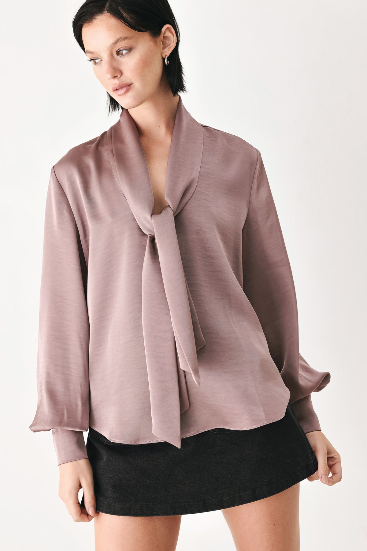 A woman wearing a dusty mauve long-sleeve silk blouse with a shawl collar and front tie | FREEMARKET