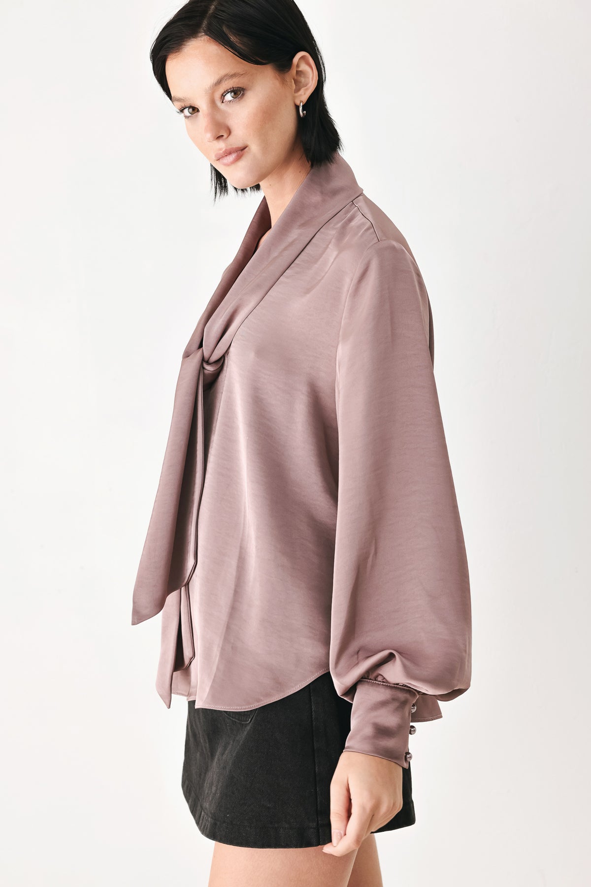 A woman wearing a dusty mauve long-sleeve silk blouse with a shawl collar and front tie | FREEMARKET