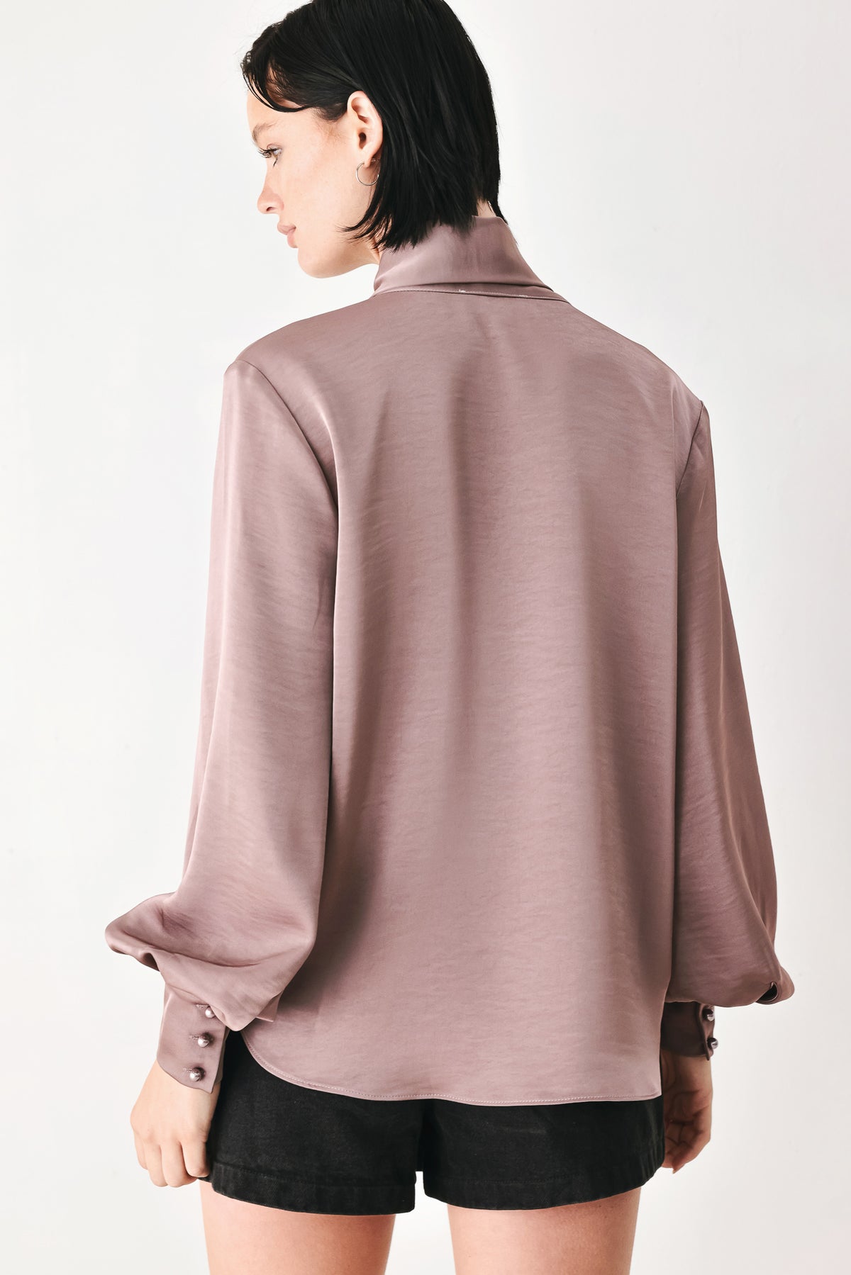 A woman wearing a dusty mauve long-sleeve silk blouse with a shawl collar and front tie | FREEMARKET