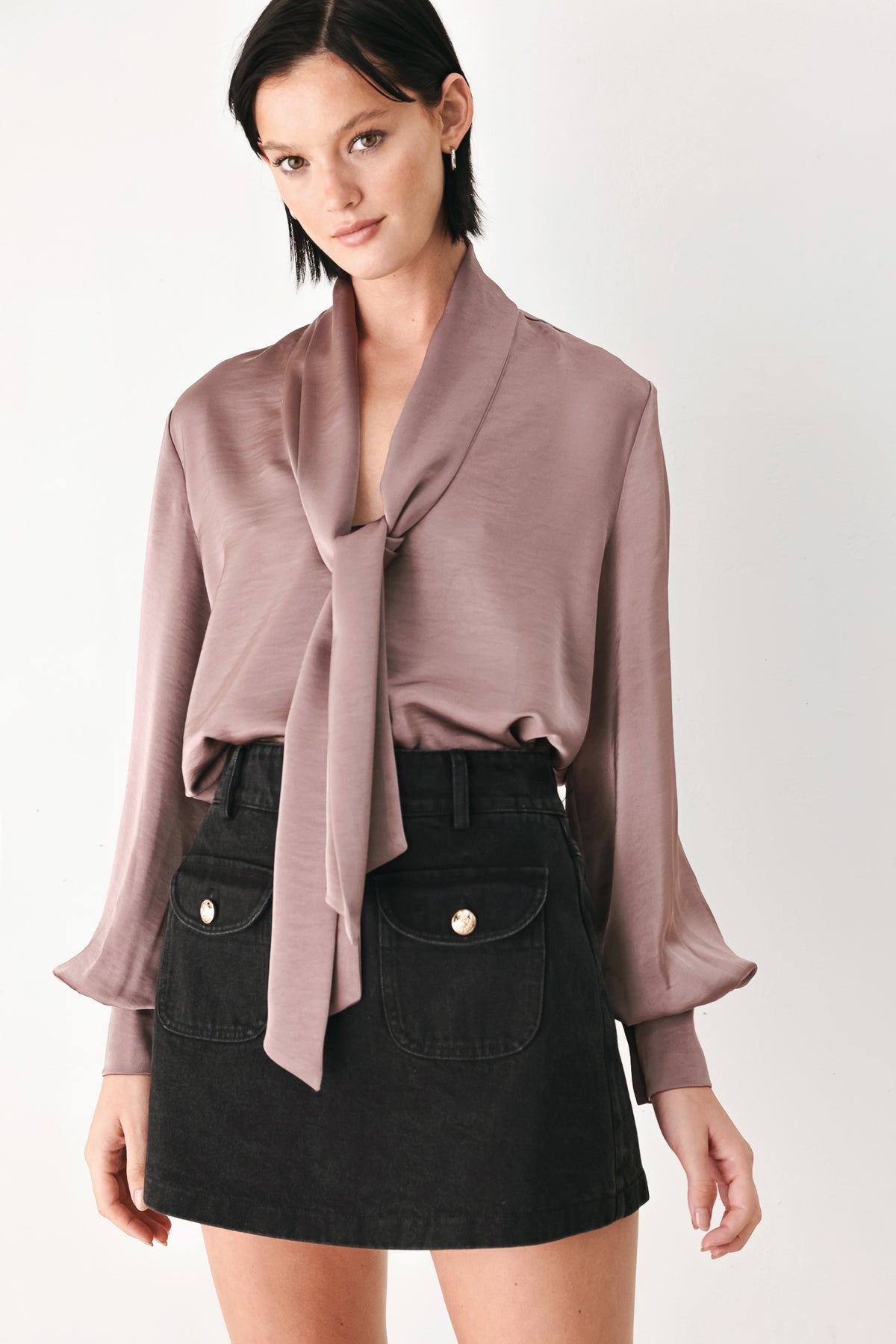 A woman wearing a dusty mauve long-sleeve silk blouse with a shawl collar and front tie | FREEMARKET