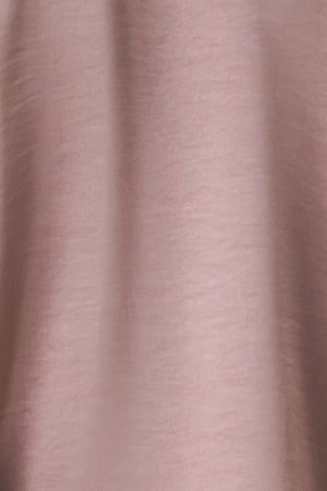 A woman wearing a dusty mauve long-sleeve silk blouse with a shawl collar and front tie | FREEMARKET