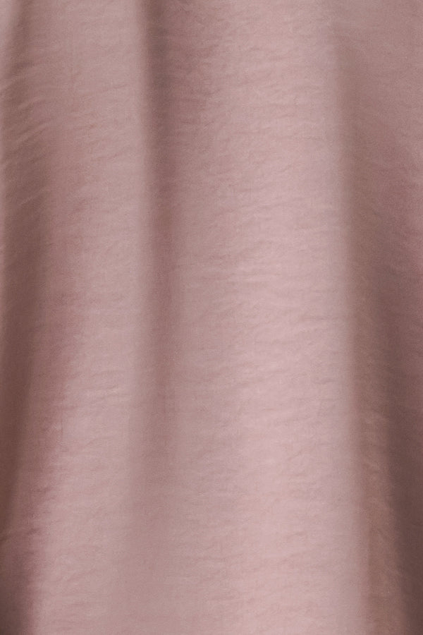 A woman wearing a dusty mauve long-sleeve silk blouse with a shawl collar and front tie | FREEMARKET