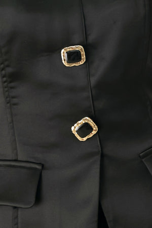 Woman wearing a strapless satin-like top with buttons along the front and two faux pockets | FREEMARKET