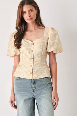 A woman wearing a beige gold jacquard corset-style blouse with puff sleeves and a sweetheart neckline | FREEMARKET