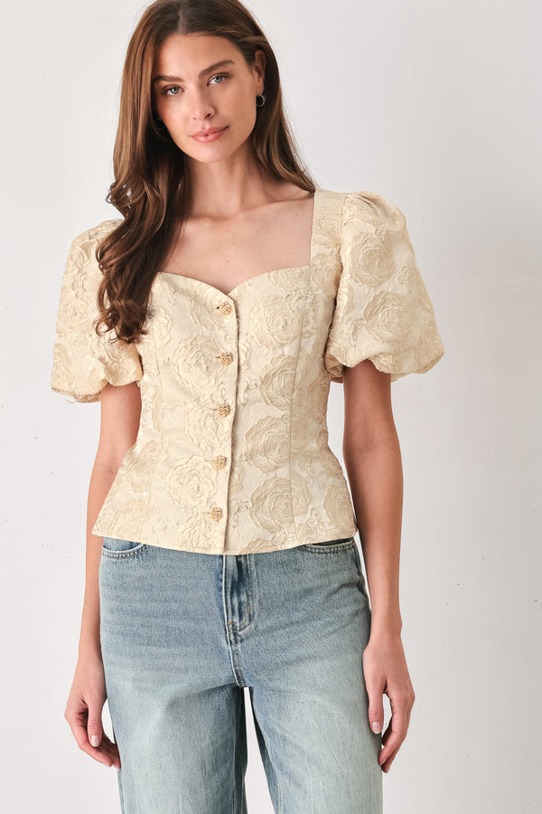 A woman wearing a beige gold jacquard corset-style blouse with puff sleeves and a sweetheart neckline | FREEMARKET