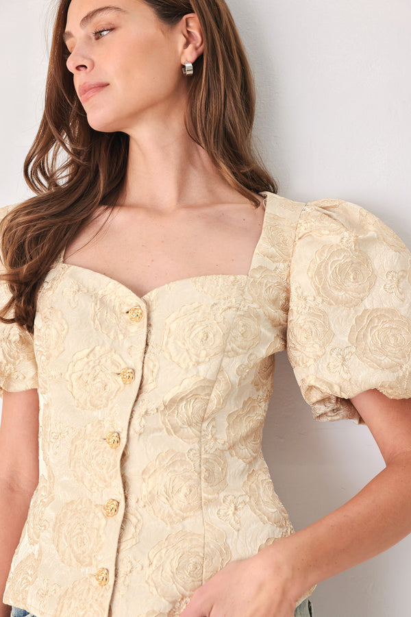 A woman wearing a beige gold jacquard corset-style blouse with puff sleeves and a sweetheart neckline | FREEMARKET