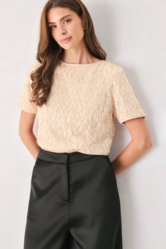 Woman wearing a champagne short sleeve crop top with sequin and faux feather/fur | FREEMARKET