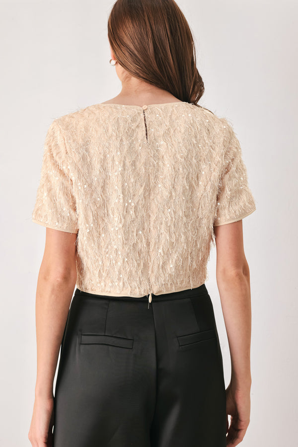 Woman wearing a champagne short sleeve crop top with sequin and faux feather/fur | FREEMARKET