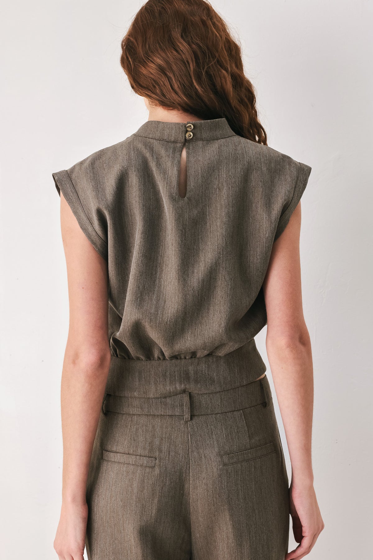 Woman wearing a brown cap sleeve top with waist belt detail | FREEMARKET