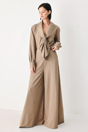 A woman wearing a taupe-beige long-sleeve button-front blouse with a large draped collar | FREEMARKET