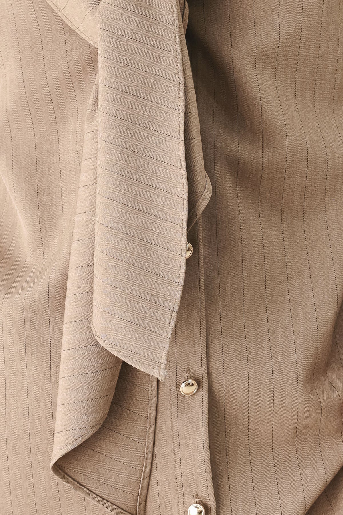 A woman wearing a taupe-beige long-sleeve button-front blouse with a large draped collar | FREEMARKET