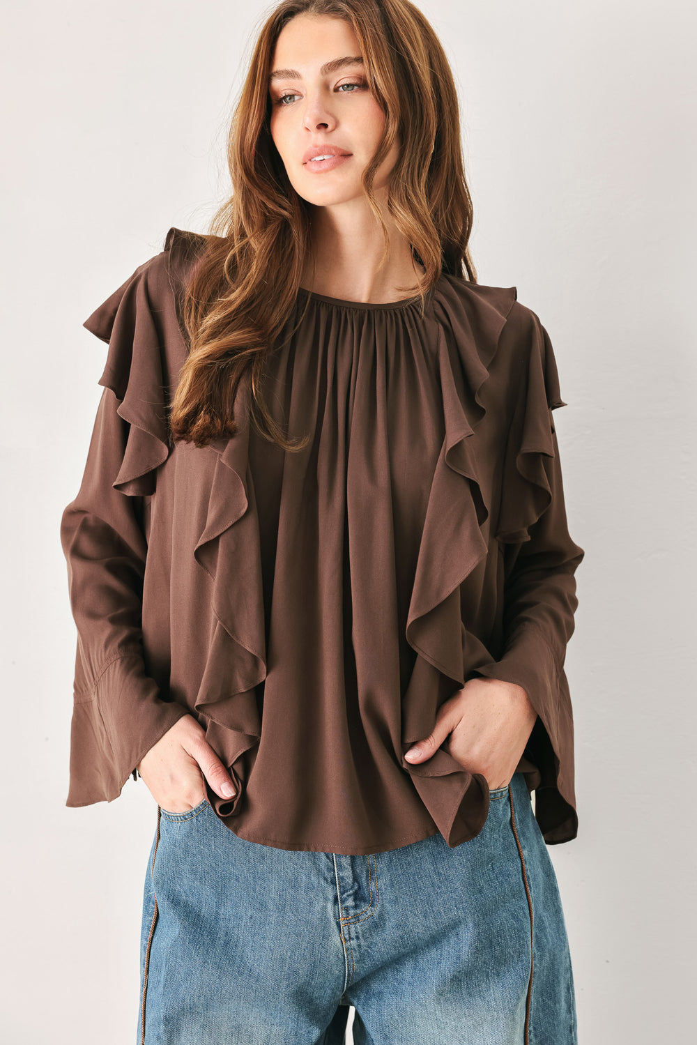 Woman wearing a long sleeve brown top with ruffles | FREEMARKET