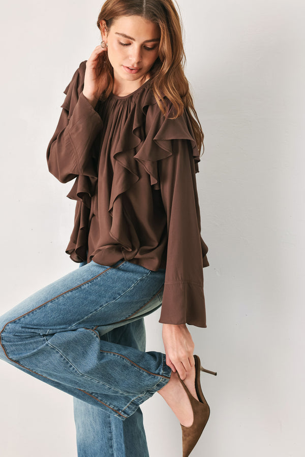 Woman wearing a long sleeve brown top with ruffles | FREEMARKET