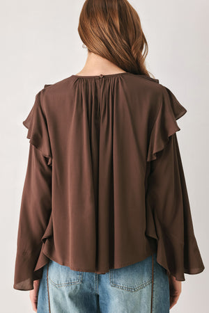 Woman wearing a long sleeve brown top with ruffles | FREEMARKET
