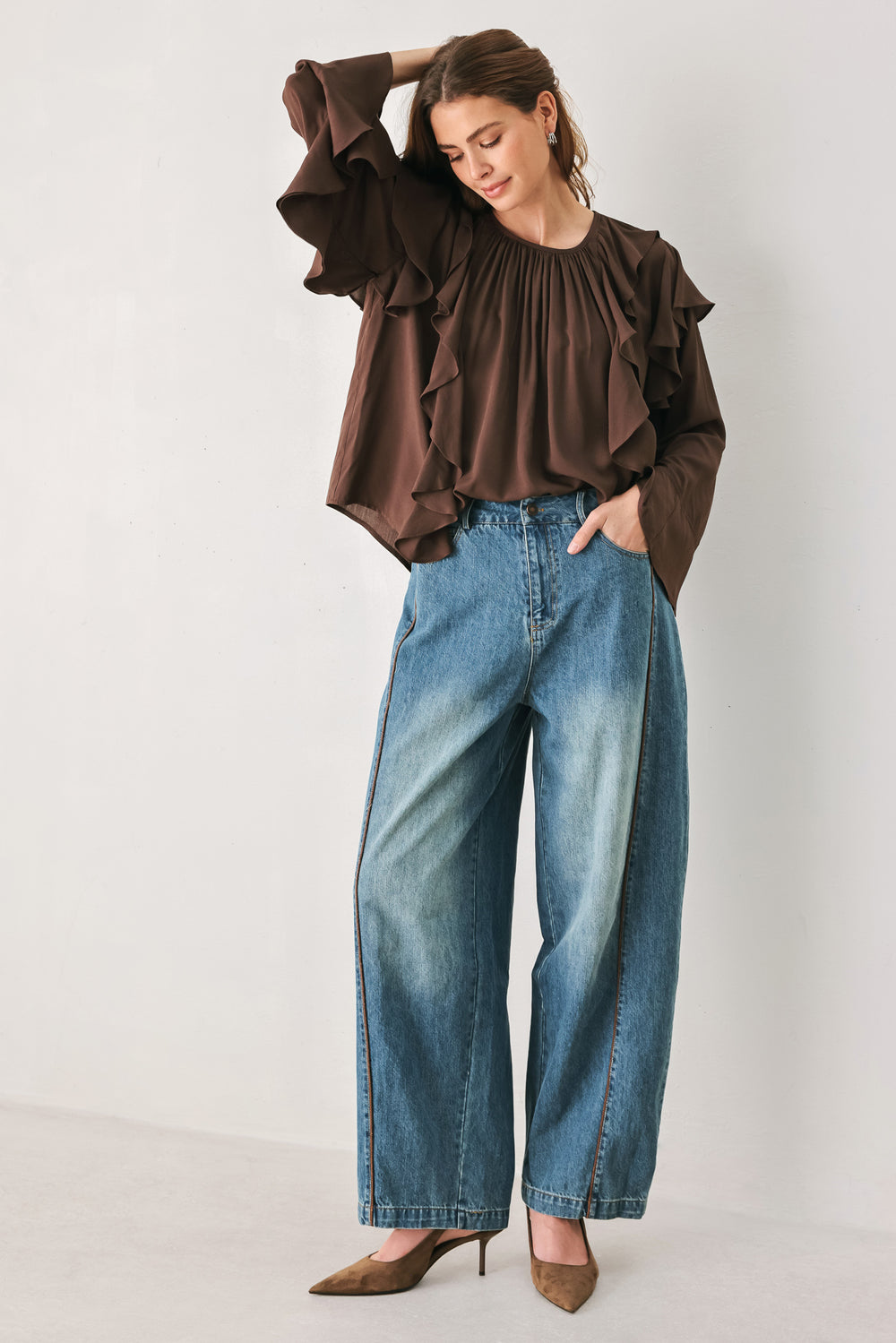 Woman wearing a long sleeve brown top with ruffles | FREEMARKET