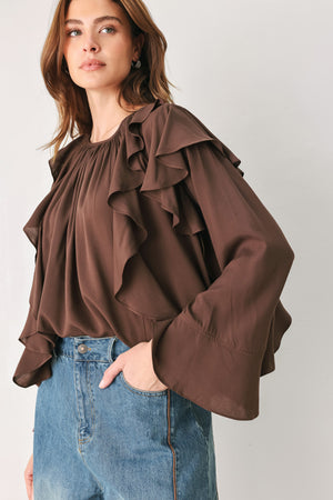Woman wearing a long sleeve brown top with ruffles | FREEMARKET