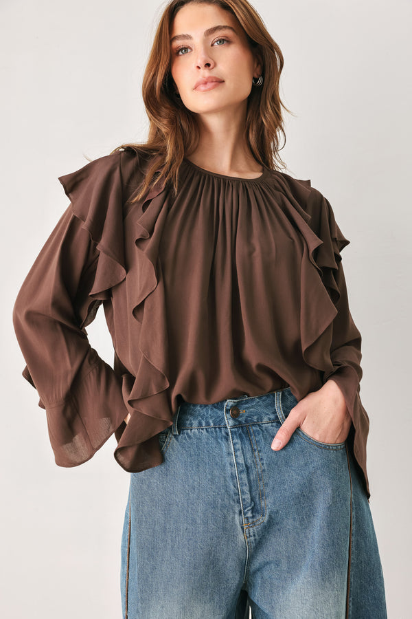 Woman wearing a long sleeve brown top with ruffles | FREEMARKET