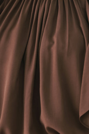 Woman wearing a long sleeve brown top with ruffles | FREEMARKET