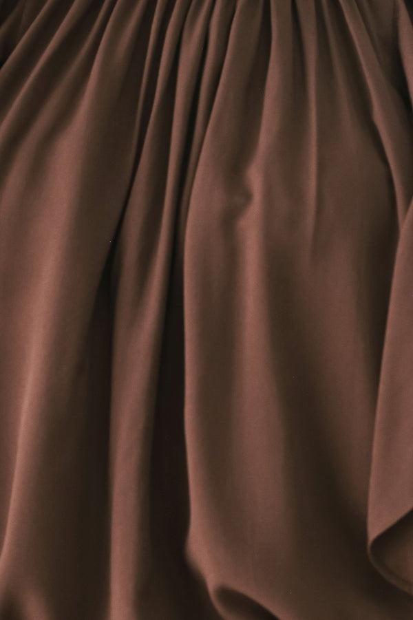 Woman wearing a long sleeve brown top with ruffles | FREEMARKET