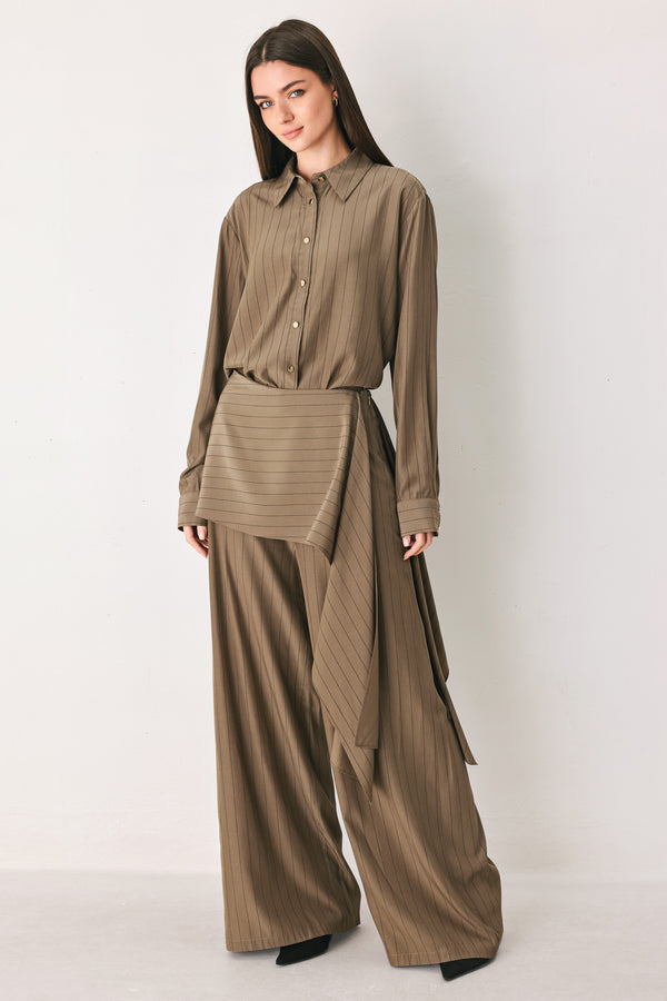 Woman wearing a brown button up long sleeve top with thin vertical black lines | FREEMARKET