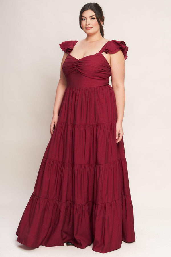 A solid woven maxi dress featuring cami top with layered sleeve, cinched front bodice, tiered skirt and smocked back bodice. FLYING TOMATO