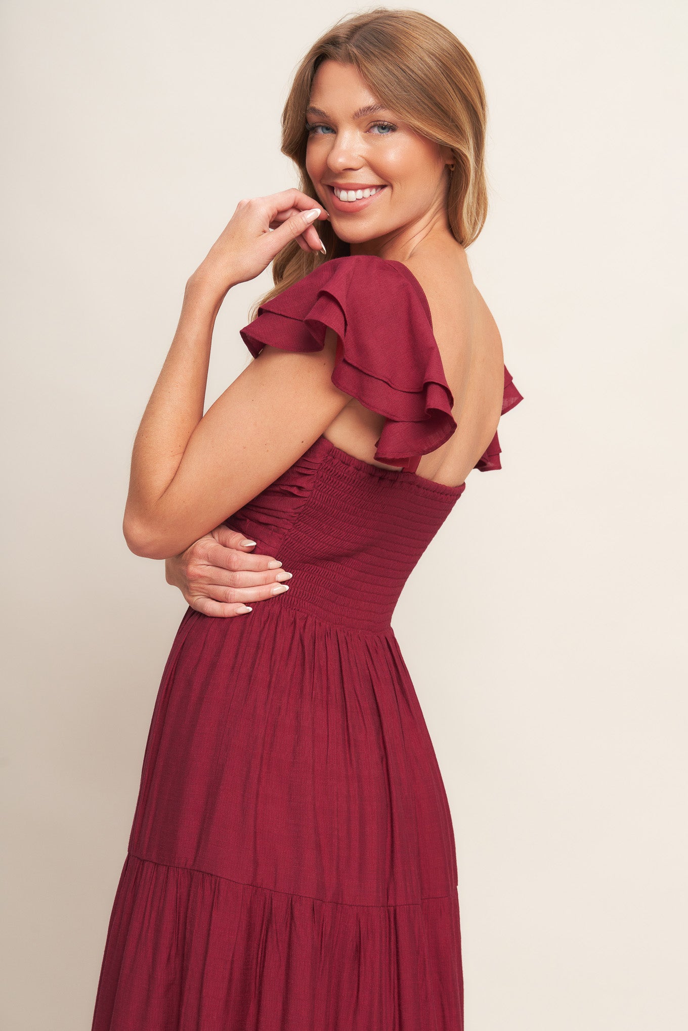 A solid woven maxi dress featuring cami top with layered sleeve, cinched front bodice, tiered skirt and smocked back bodice.