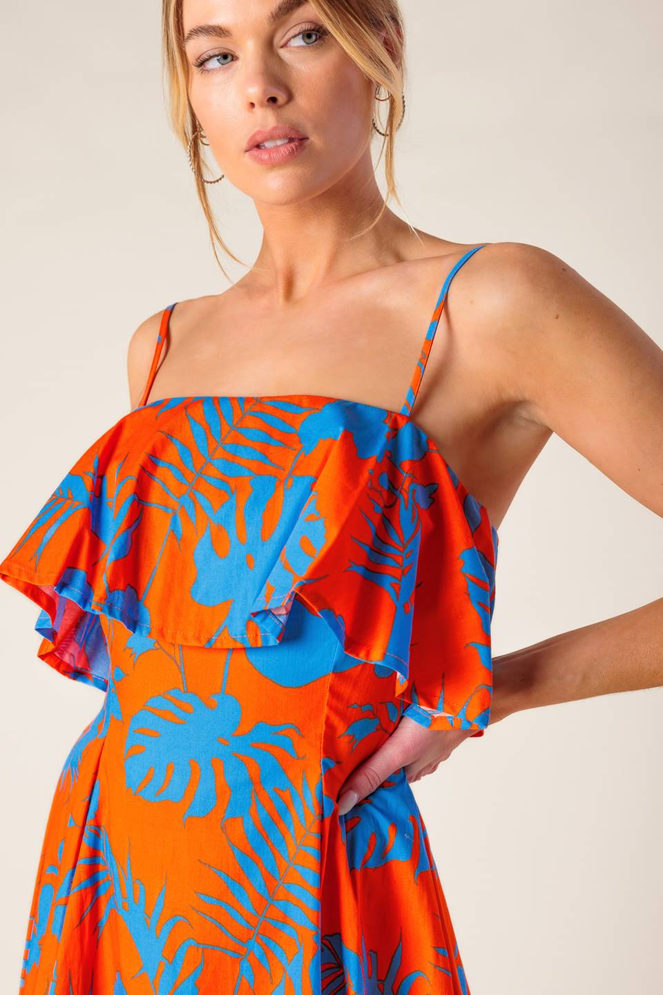 A printed woven mini dress featuring straight neckline, straps, flounce, full skirt and back zipper closure