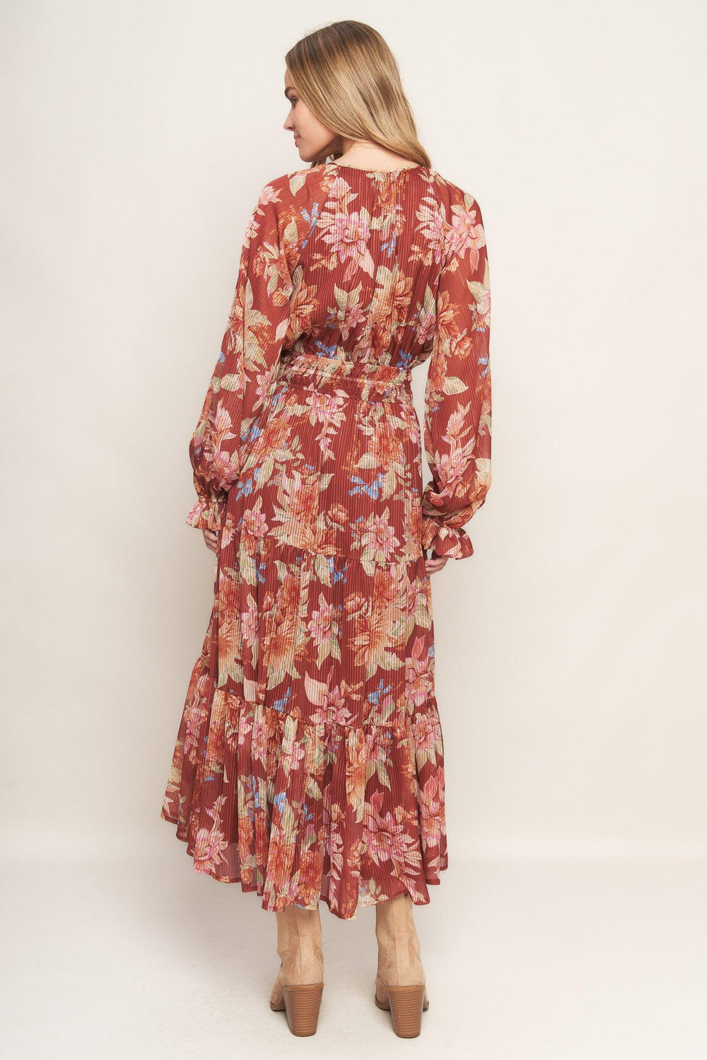 A printed woven midi dress featuring round neckline with front tie, long sleeve, elasticized waist and tiered skirt