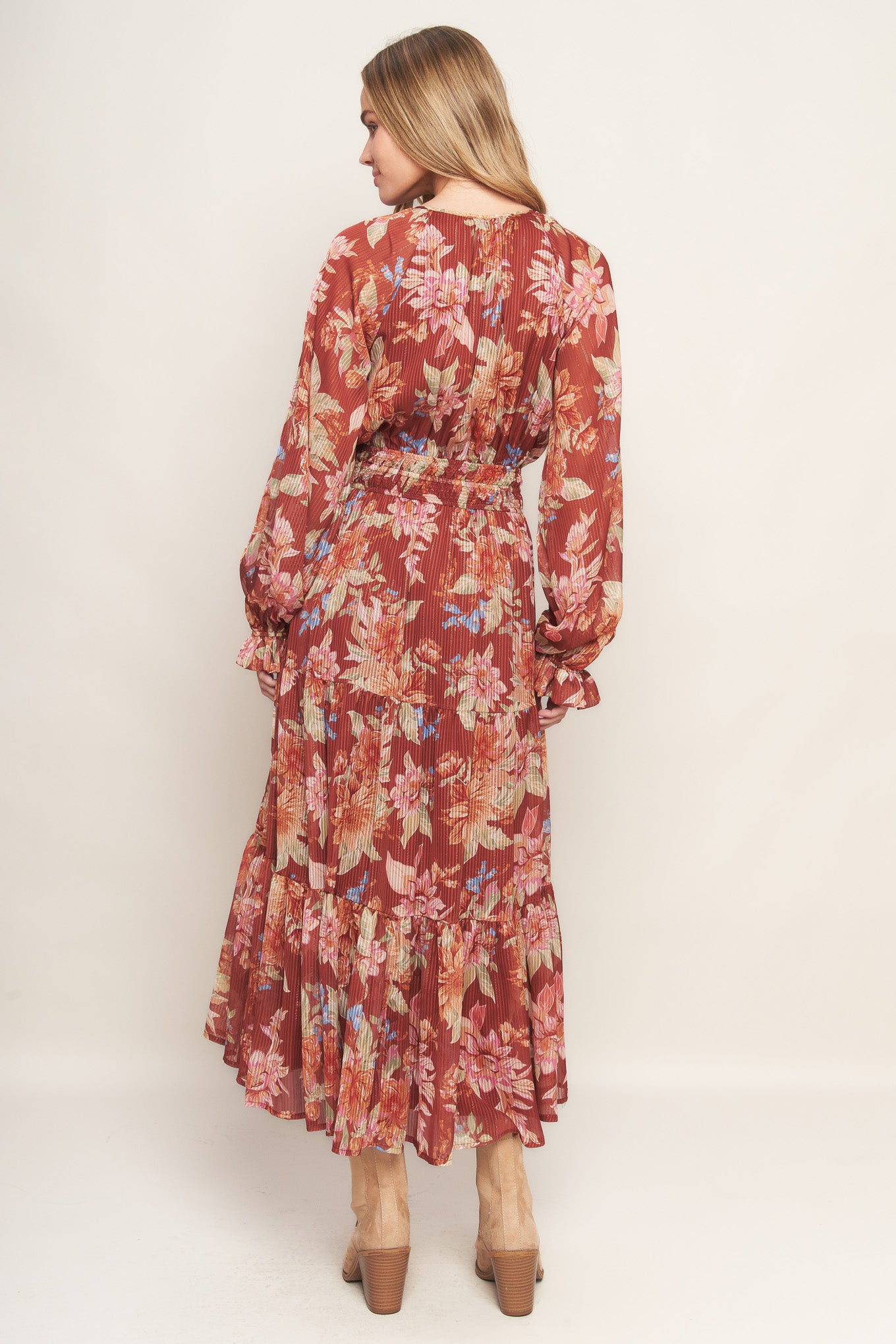 A printed woven midi dress featuring round neckline with front tie, long sleeve, elasticized waist and tiered skirt