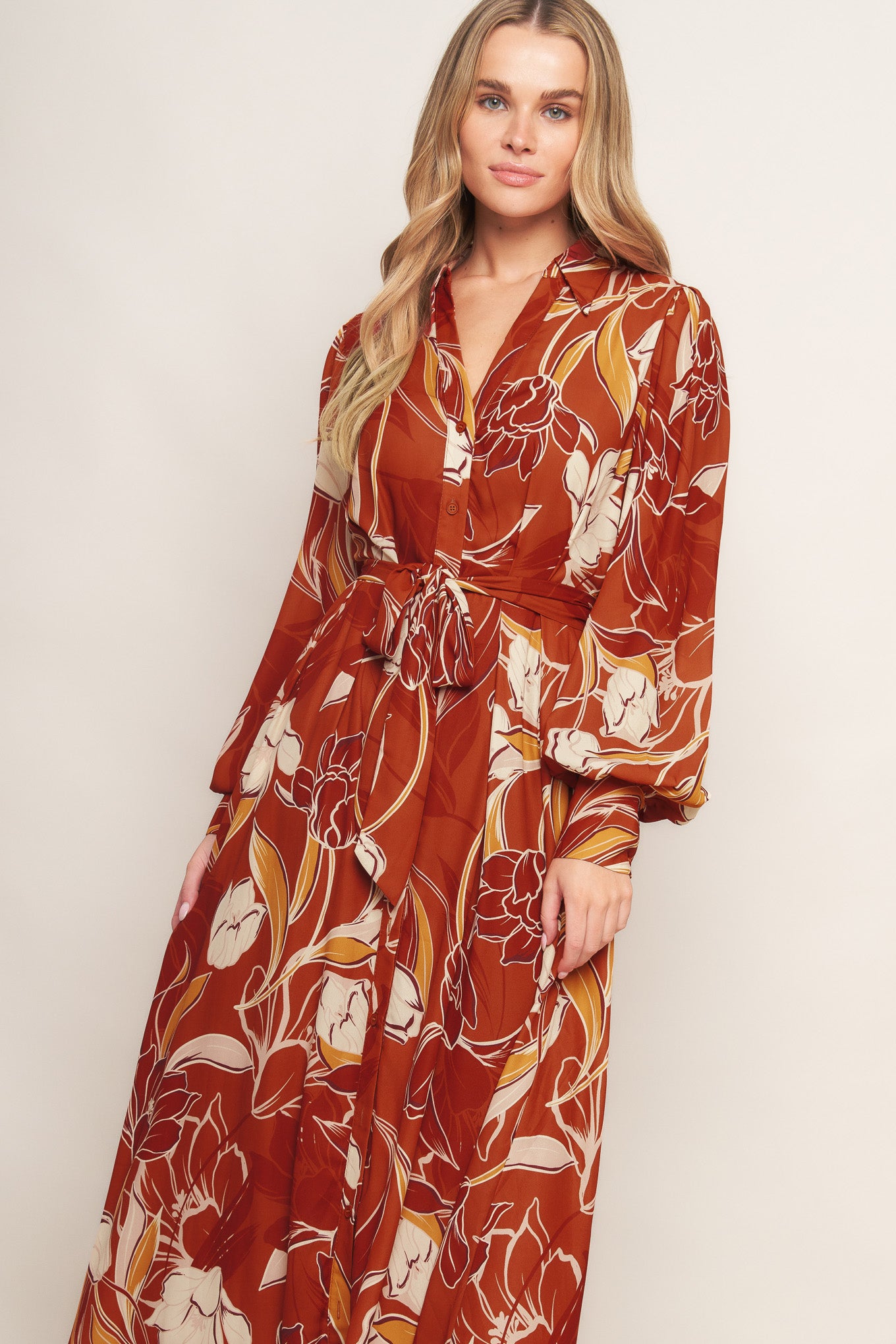 A printed woven midi dress featuring shirt collar, V neckline, long sleeves, button down, self sash tie and full skirt