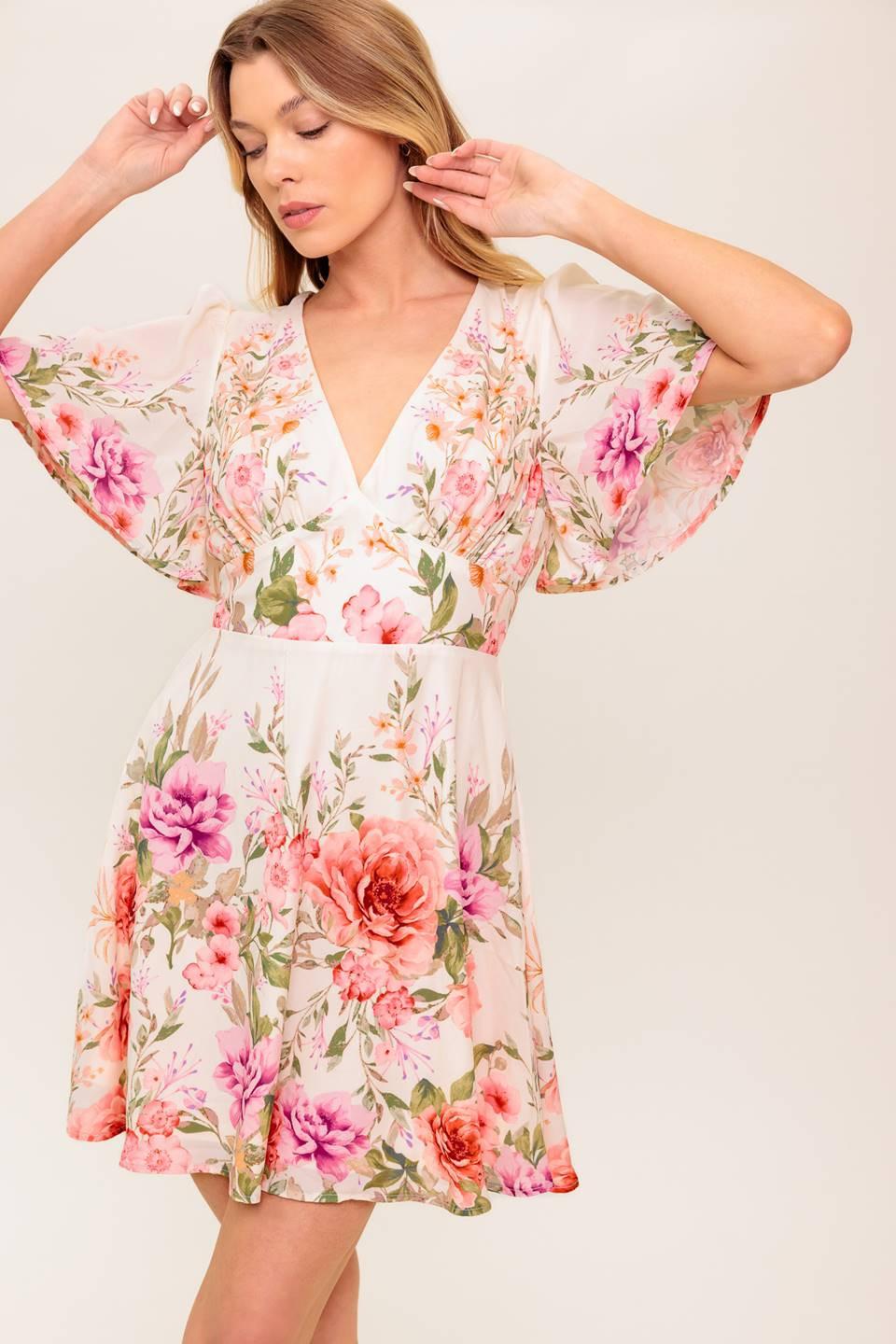 A printed woven mini dress featuring V neckline, long sleeve, waist yoke, ruffled hemline and back zipper closure