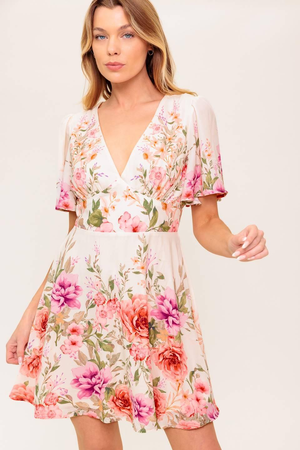 A printed woven mini dress featuring V neckline, long sleeve, waist yoke, ruffled hemline and back zipper closure