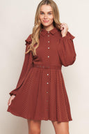 A textured woven mini dress featuring shirt collar, button down, long sleeve with ruffled shoulder, self belt and full skirt