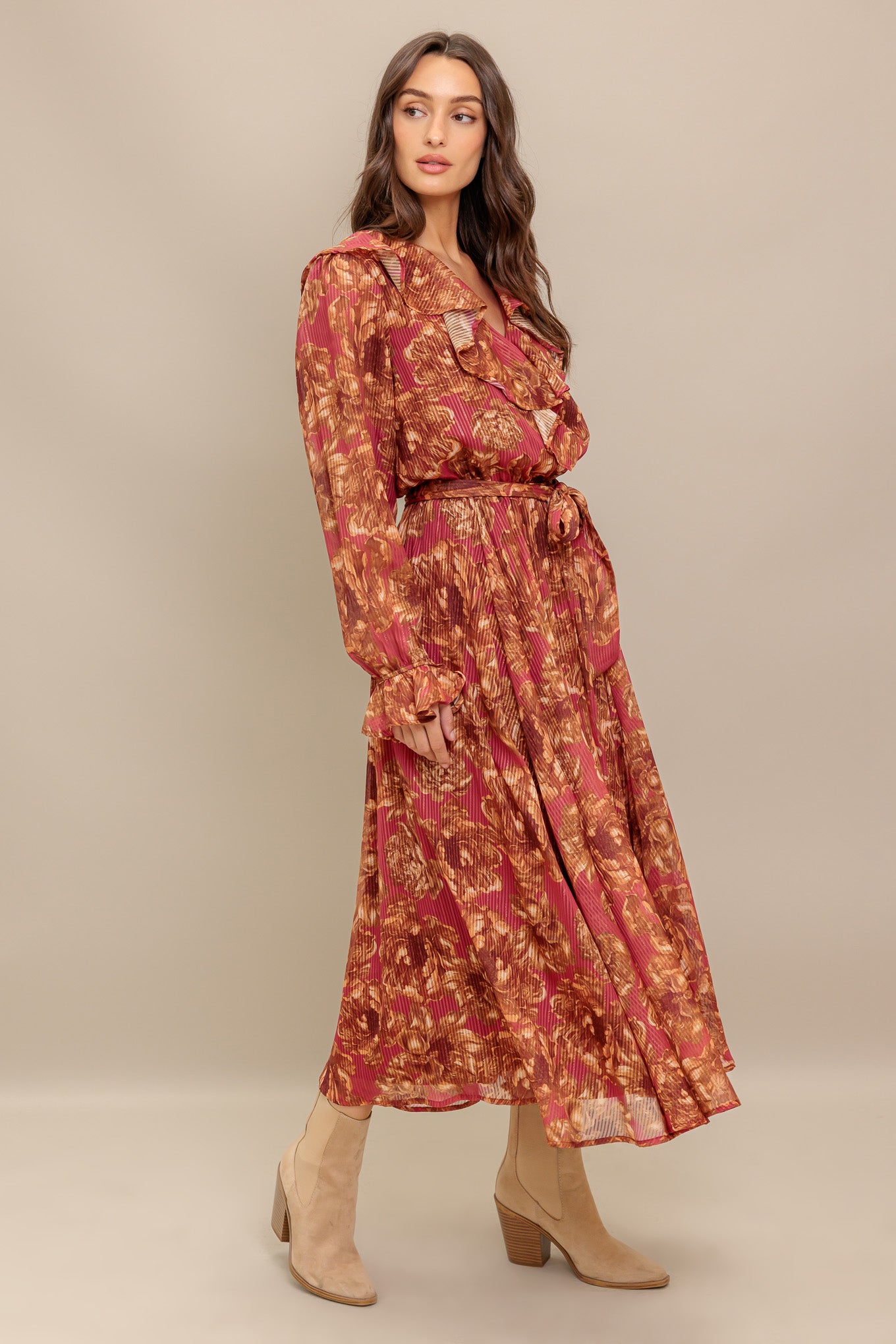 A printed woven midi dress featuring surplice neckline with ruffles, long sleeve with ruffled cuff, elasticized waist with self sash tie and full skirt