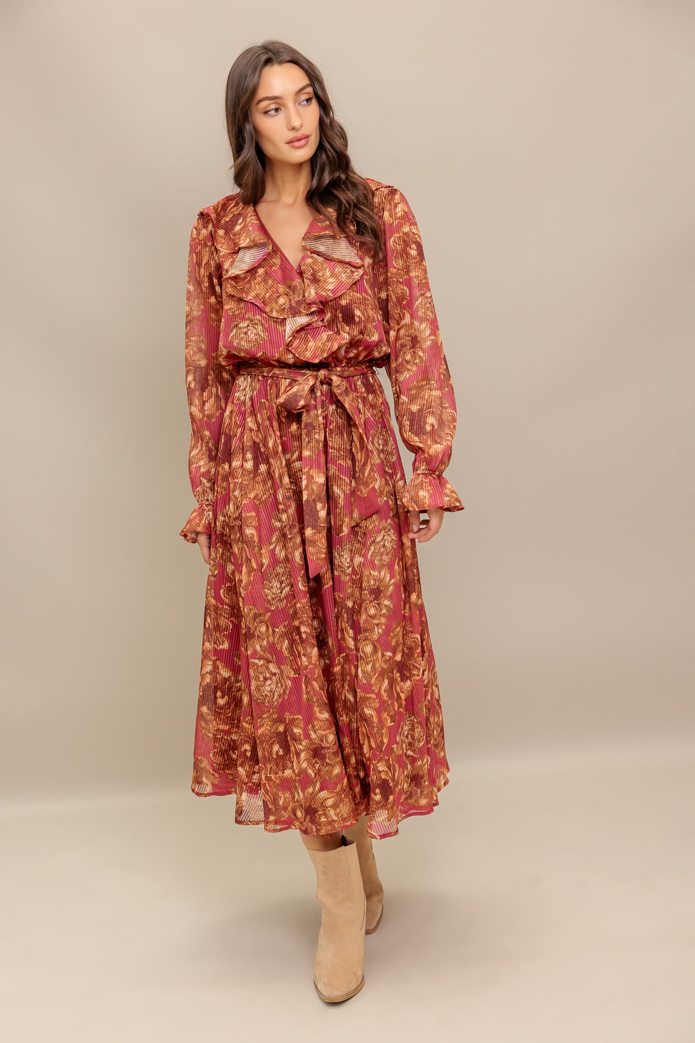A printed woven midi dress featuring surplice neckline with ruffles, long sleeve with ruffled cuff, elasticized waist with self sash tie and full skirt