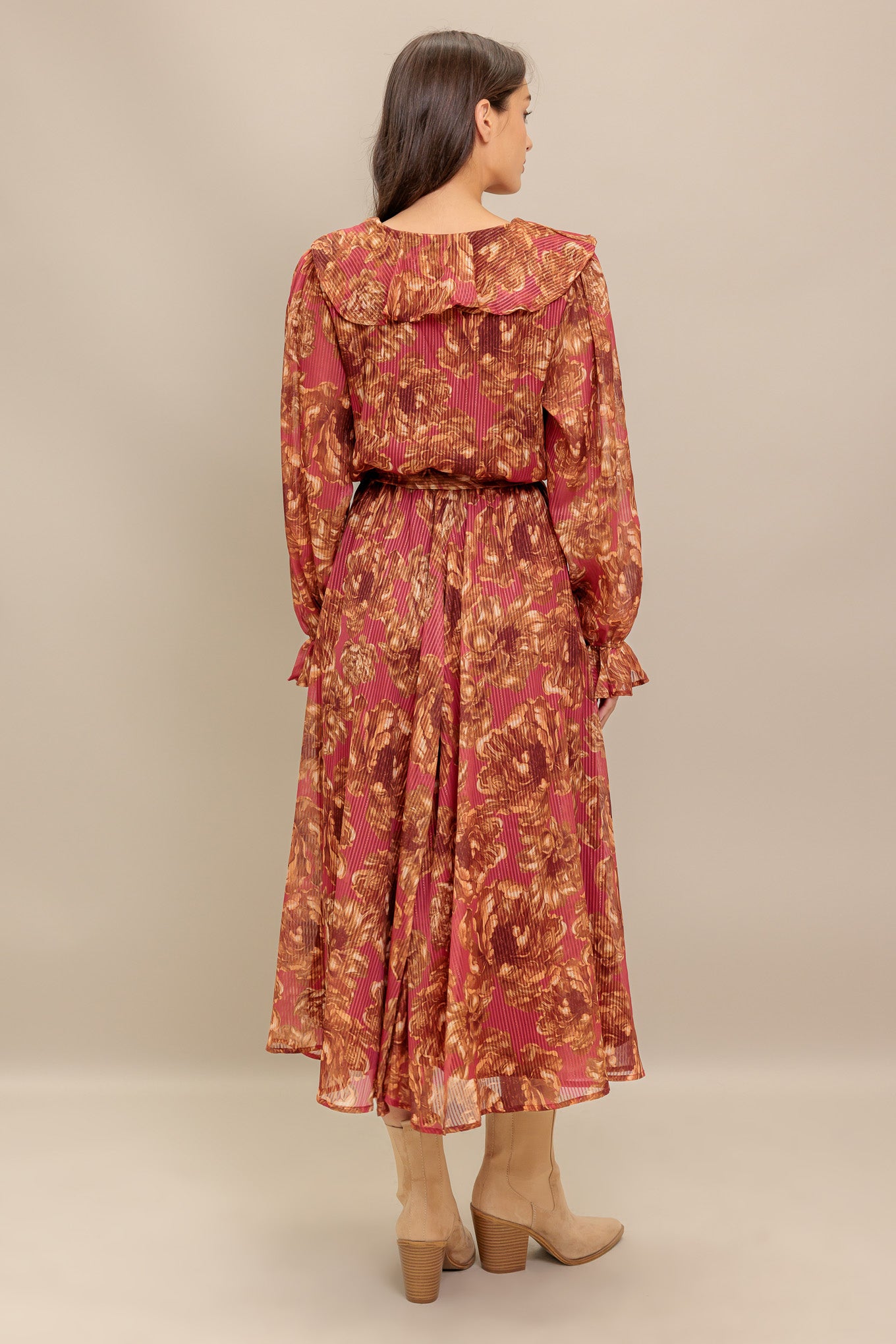 A printed woven midi dress featuring surplice neckline with ruffles, long sleeve with ruffled cuff, elasticized waist with self sash tie and full skirt