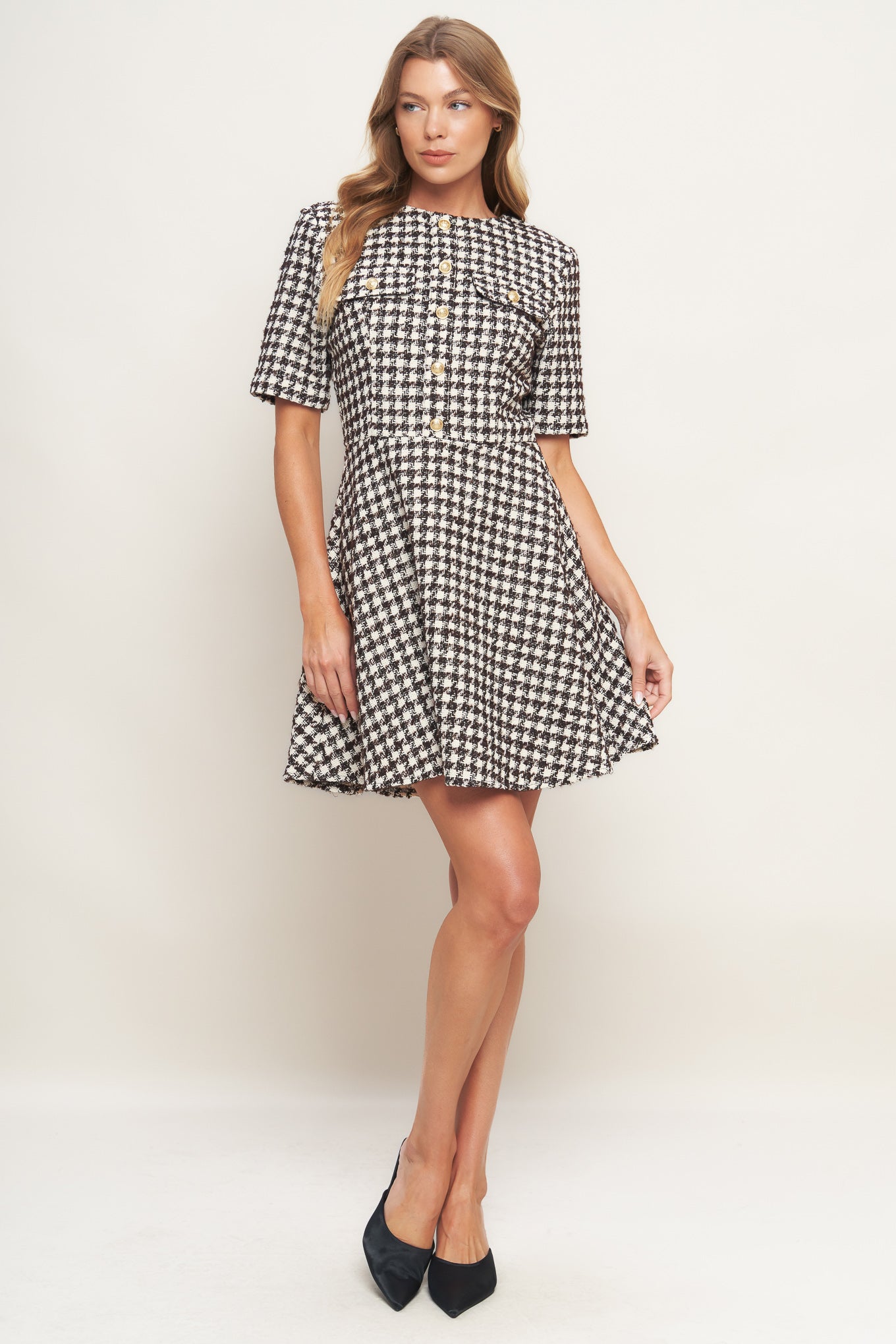 A tweed mini dress featuring round neckline, short sleeve, front button detail, A line skirt and back zipper closure
