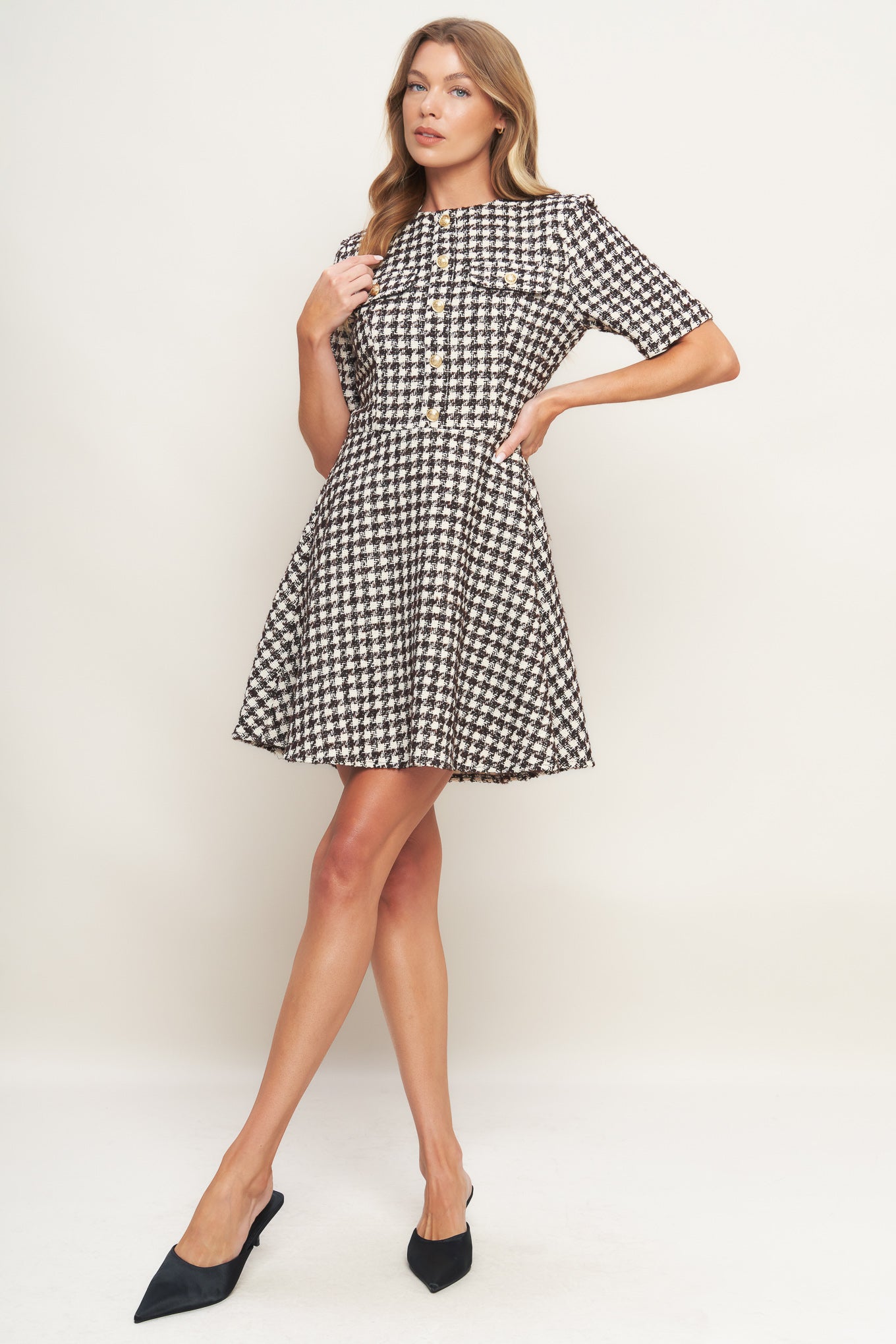 A tweed mini dress featuring round neckline, short sleeve, front button detail, A line skirt and back zipper closure