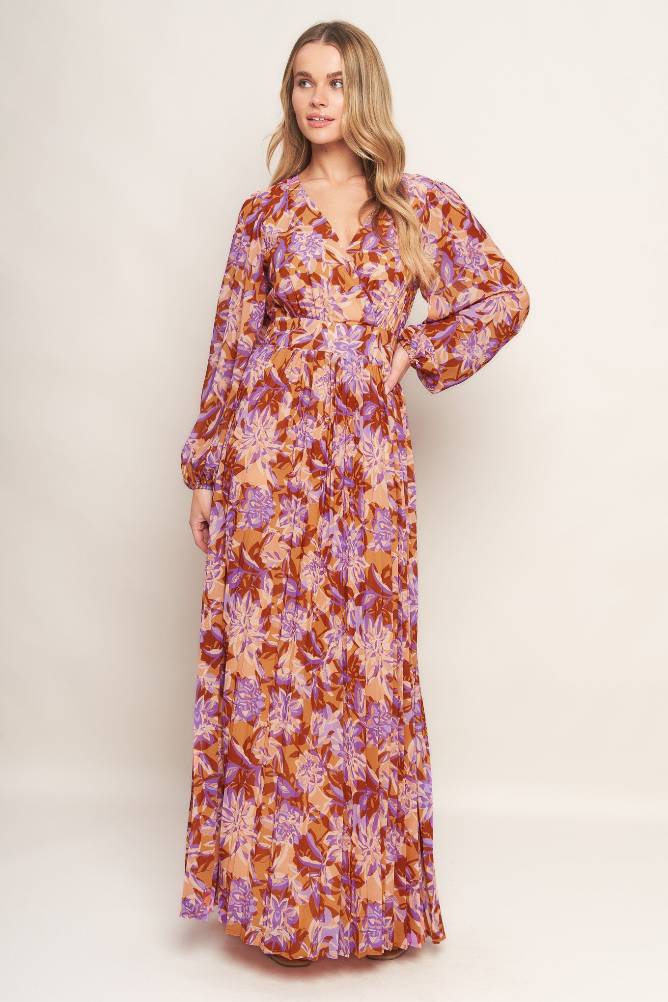 A printed woven maxi dress featuring surplice neckline, long blouson sleeve, pleated skirt and back zipper closure