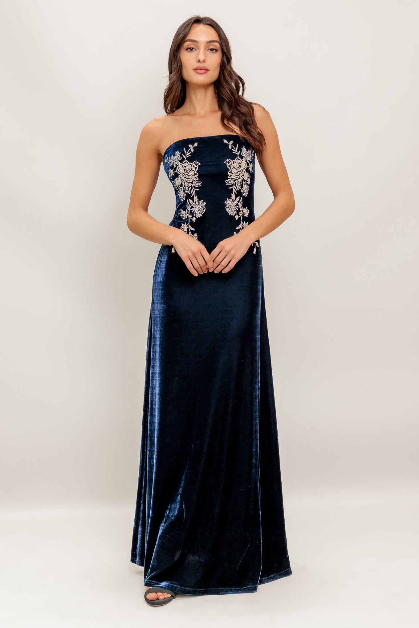 A velvet maxi dress featuring strapless, embroidered bodice and back zipper closure