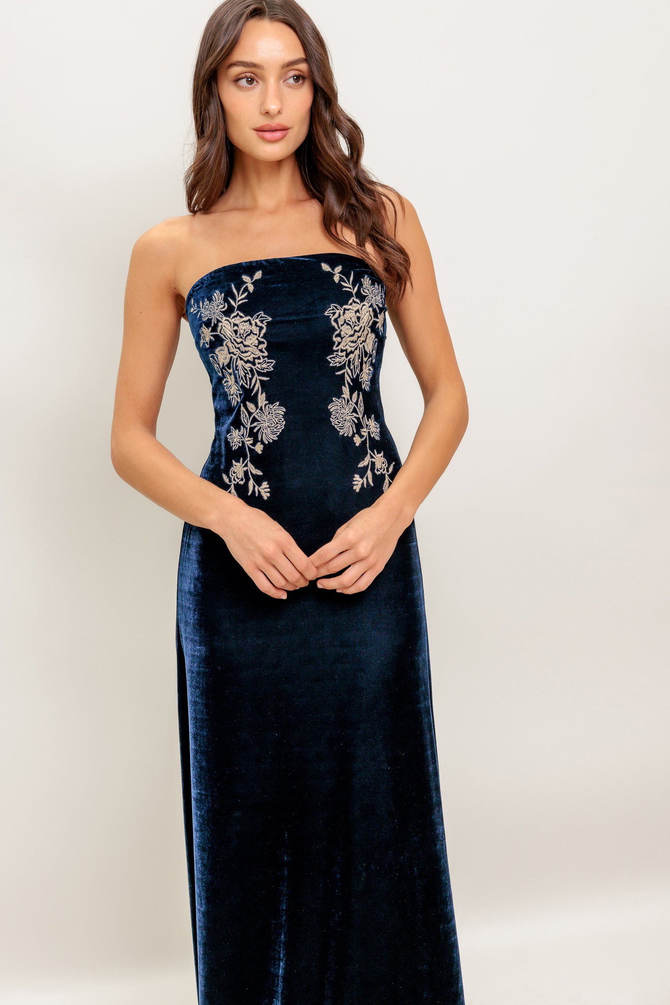 A velvet maxi dress featuring strapless, embroidered bodice and back zipper closure
