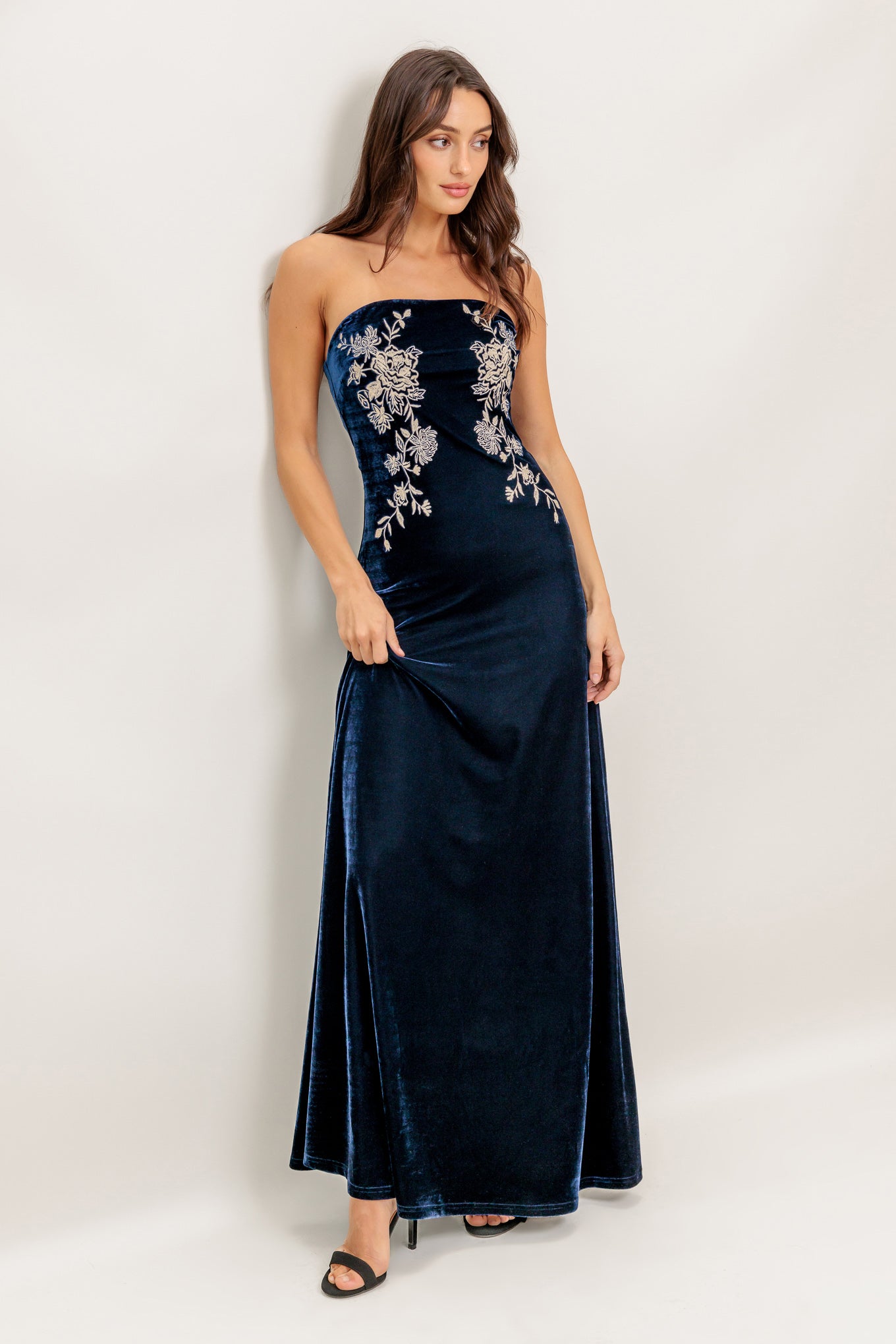 A velvet maxi dress featuring strapless, embroidered bodice and back zipper closure