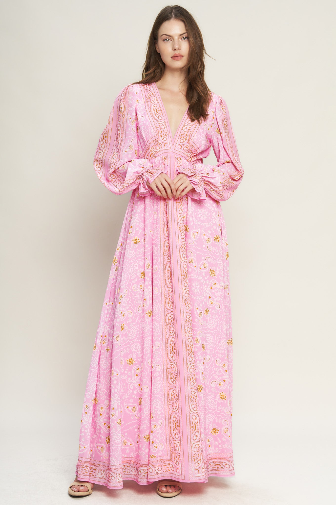 A printed woven maxi dress featuring a V neckline, long sleeve with ruffled cuff, and elasticized waist