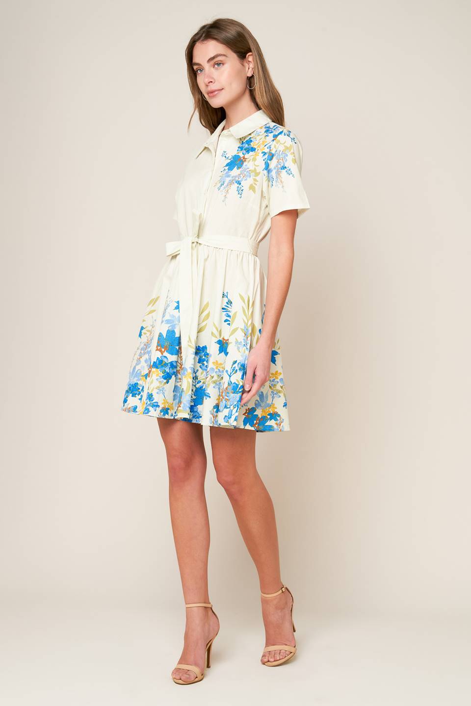 A printed woven mini dress featuring shirt collar, button down, short sleeve, self sash tie and full skirt.