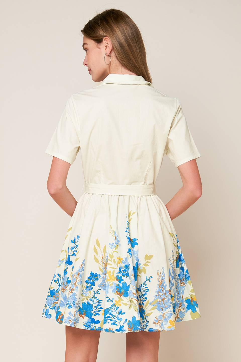 A printed woven mini dress featuring shirt collar, button down, short sleeve, self sash tie and full skirt.