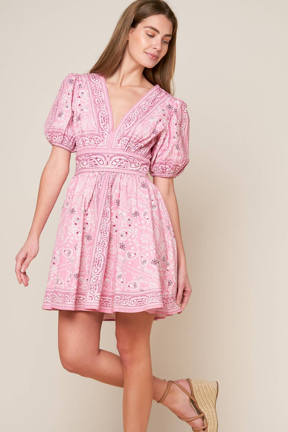 This woven mini dress boasts a printed design with a V neckline, short puff sleeves, a wide waistband, a full skirt and a convenient back zipper closure.