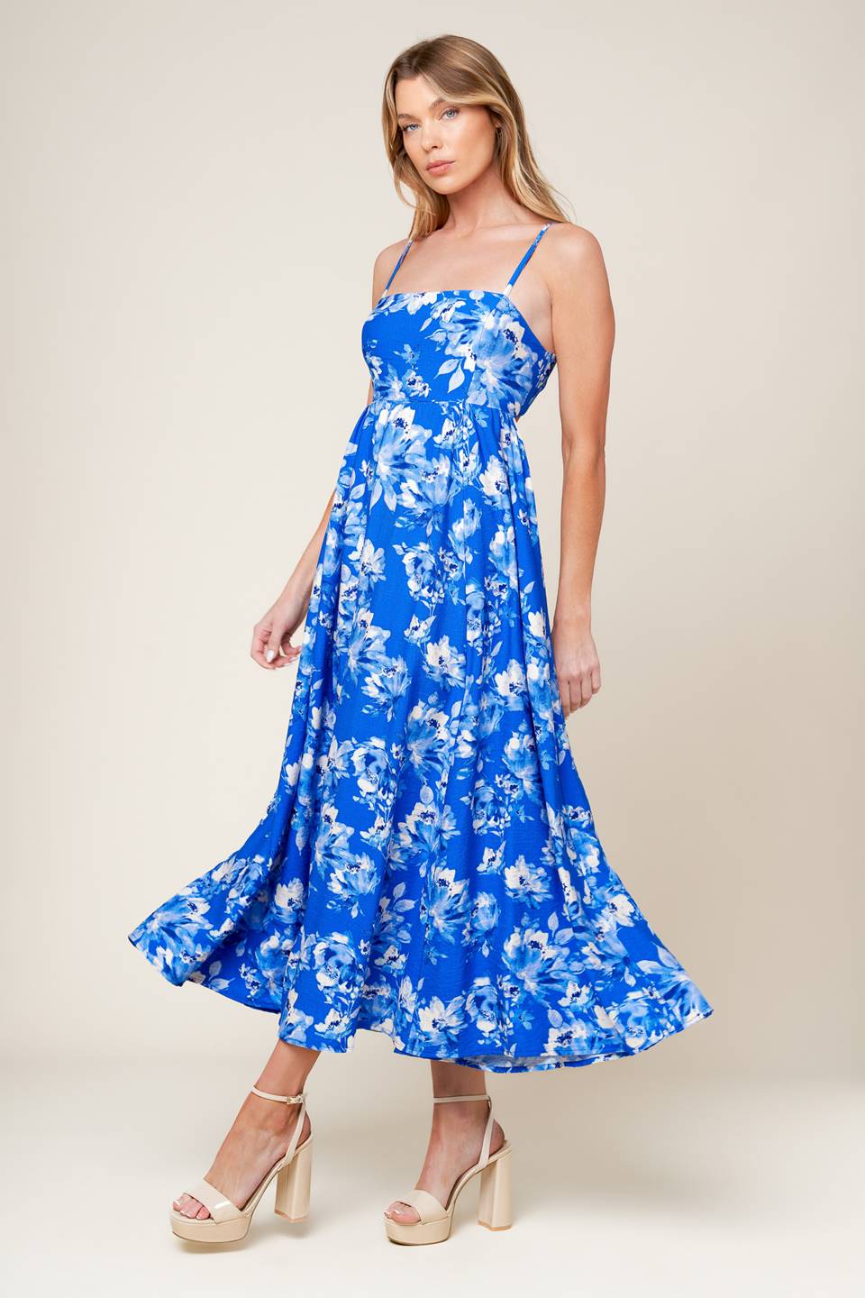 A printed woven midi dress featuring straight neckline, straps, full skirt, back tie and elasticized back